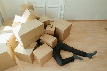Person underneath a pile of boxes